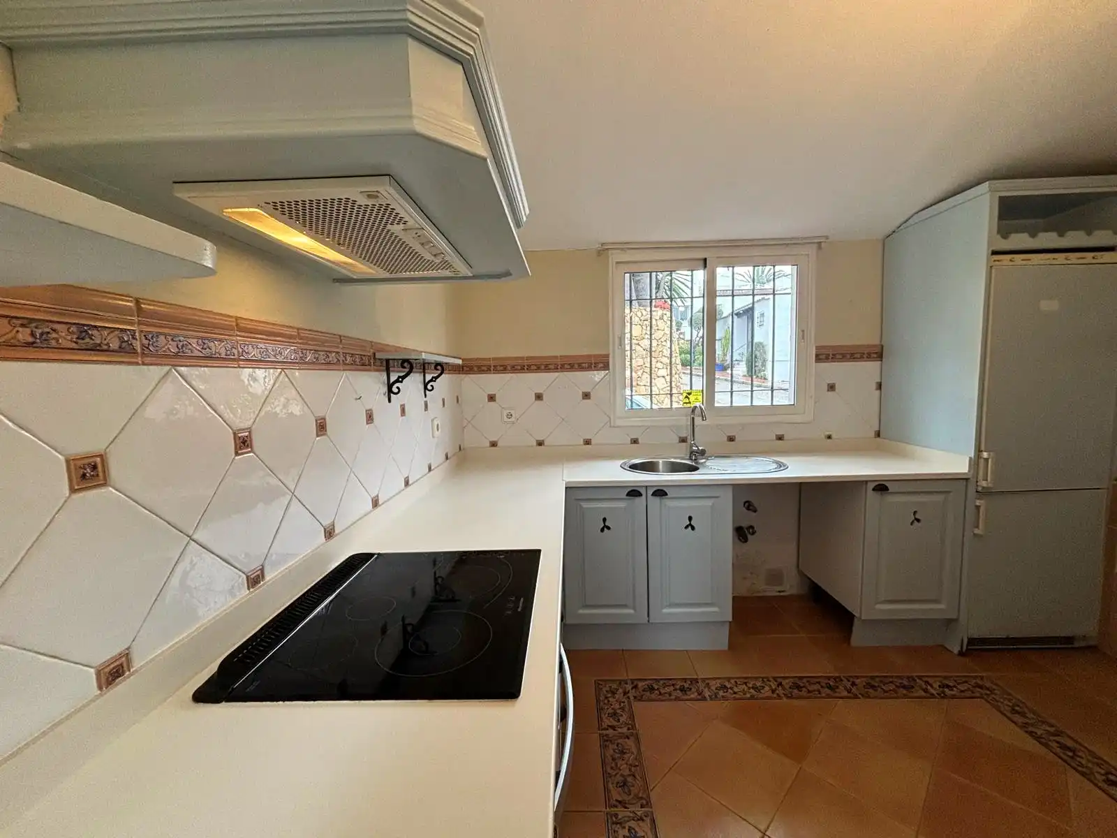 Bright independent kitchen with generous worktop space and an exterior window in the Brisas II, Manilva home.
