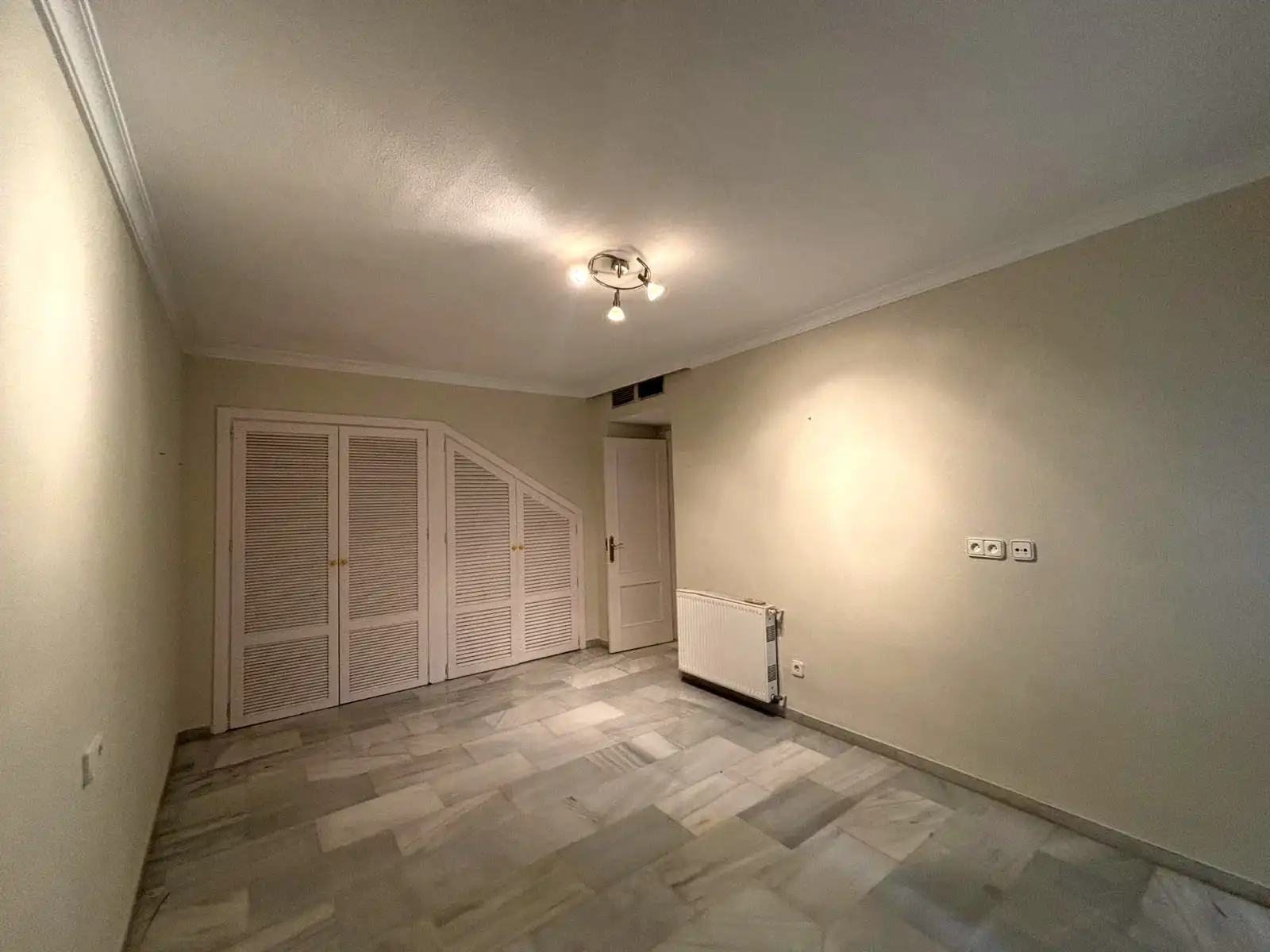 Schlafzimmer mit Einbauschränken, Heizkörper und Marmorboden in Brisas II, Manilva.