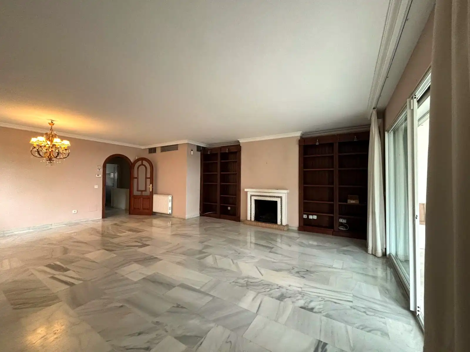 Very spacious living-dining room with built-in shelving, fireplace and marble floors in Brisas II, Manilva.