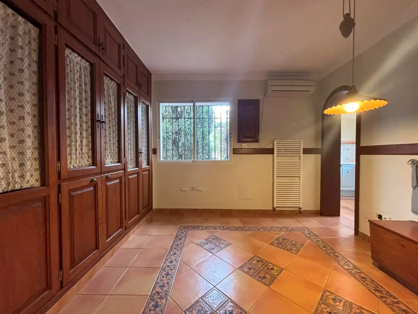 Office-Bereich neben der Küche mit Holzschränken, Eckbank und direktem Zugang zur Küche.