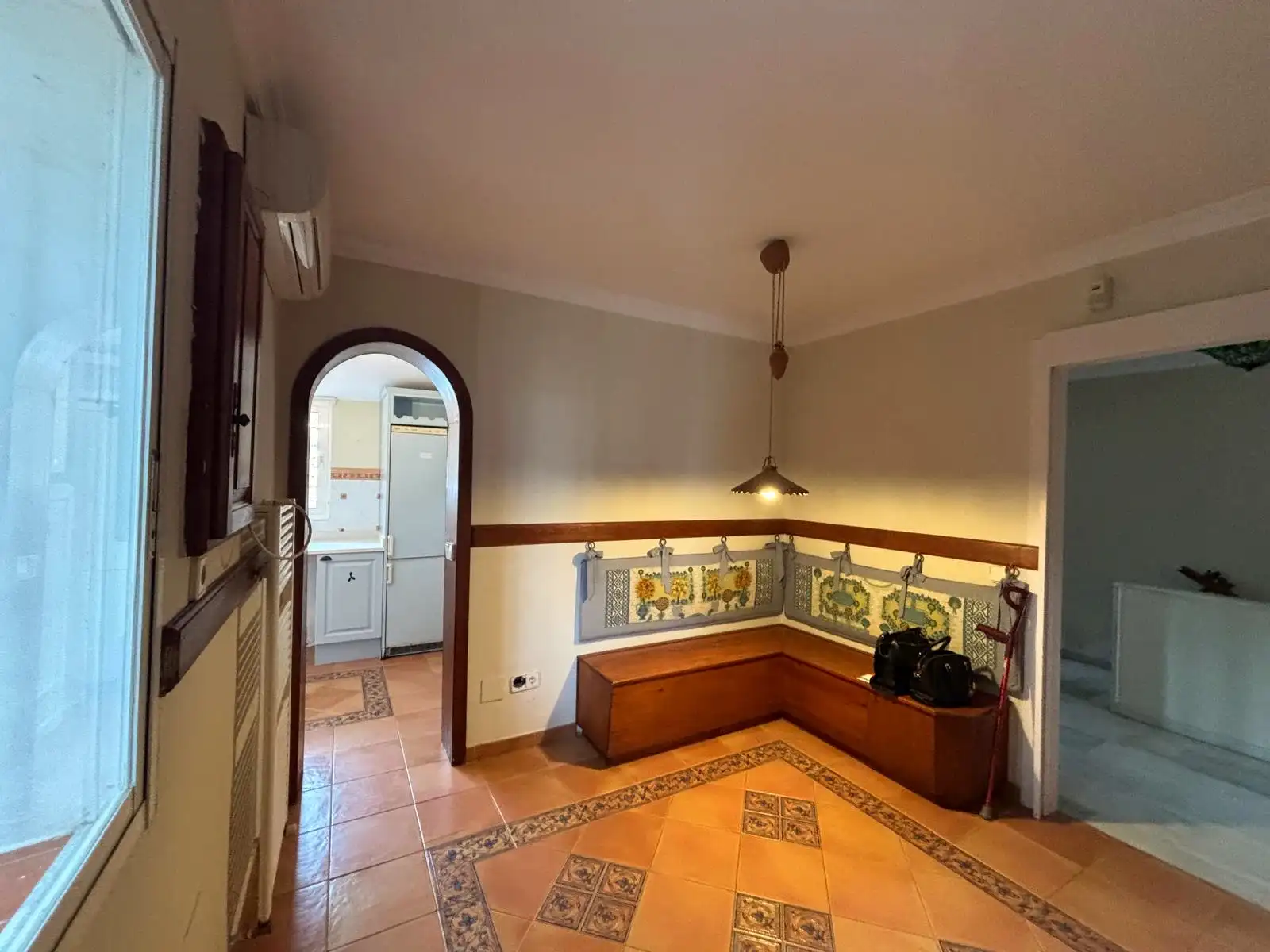 Office-Bereich neben der Küche mit maßgefertigten Holzschränken und Keramikboden.